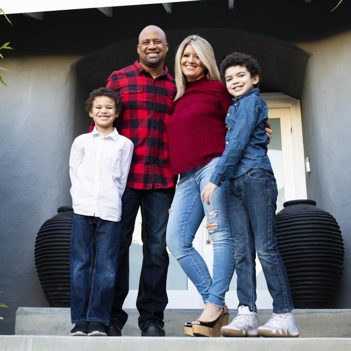 happy family standing on front steps of new home